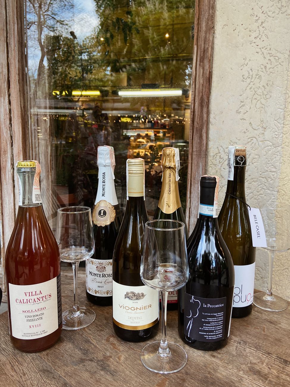 Carta de vinhos italianos com taças e garrafa em mesa rústica